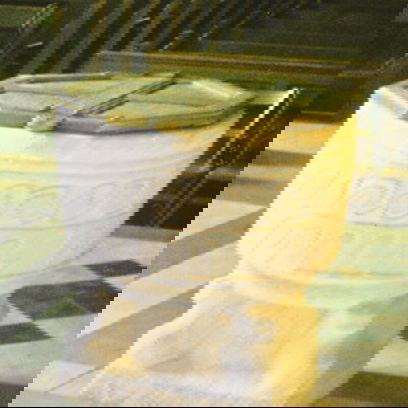 Das Bild zeigt einen steinernen Taufstein, dessen Becken in der Mitte geteilt ist.