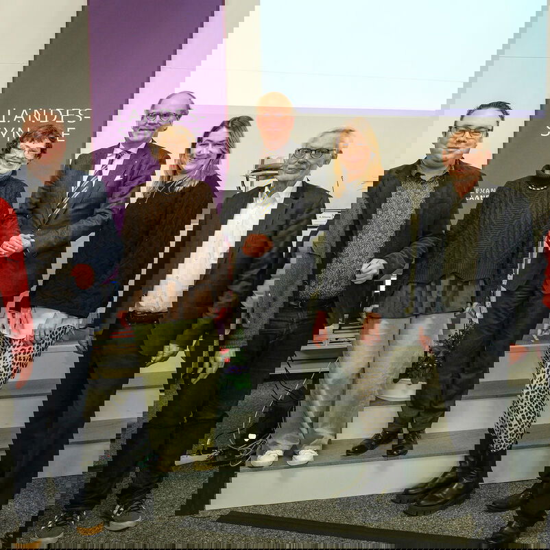 Mehrere Personen stehen zusammen und lächeln in die Kamera