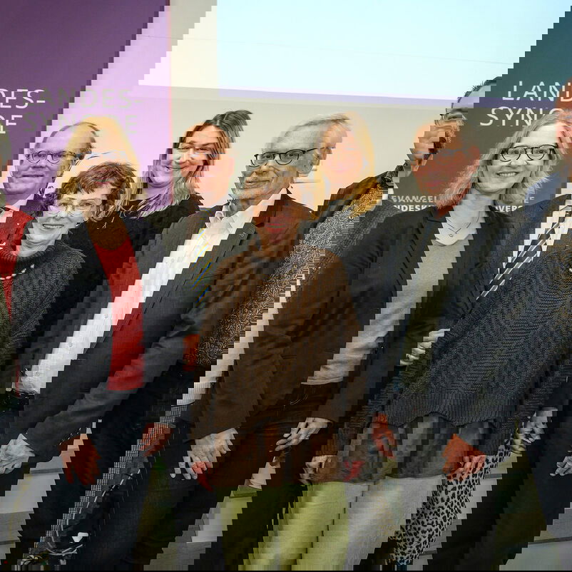 Mehrere Personen stehen zusammen und lächeln in die Kamera