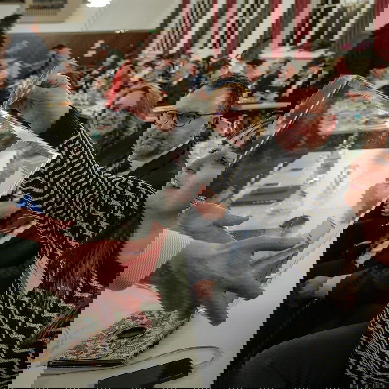 Eine weiblich lesbare Person wirft einen Stimmzettel in eine Wahlurne