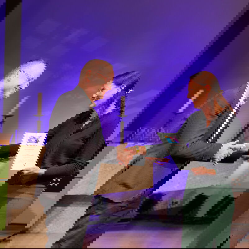 Ein Mann überreicht einer Frau einen Preis.