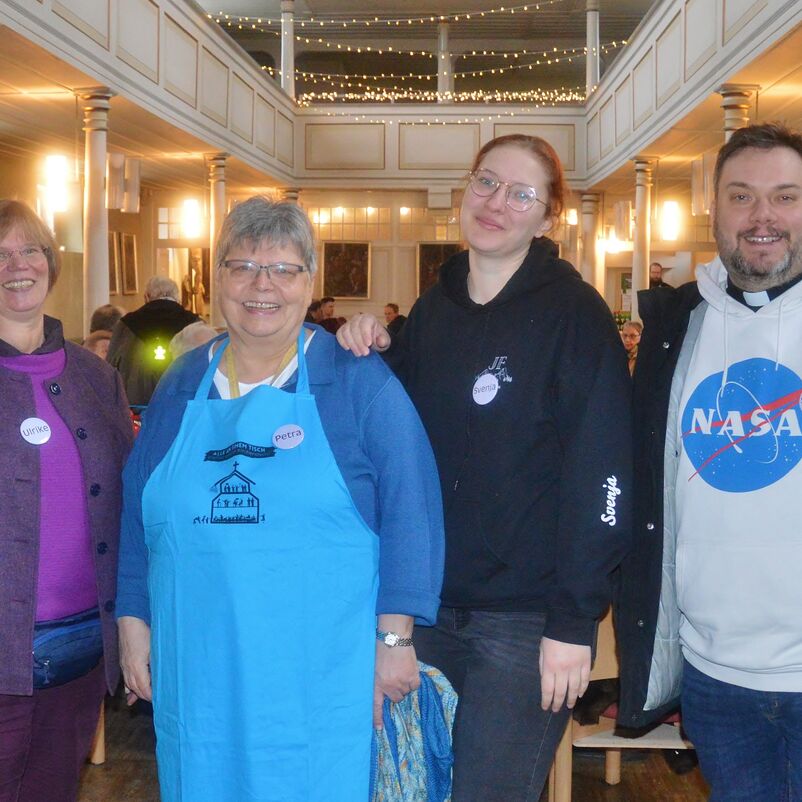 Vier Menschen lächeln.