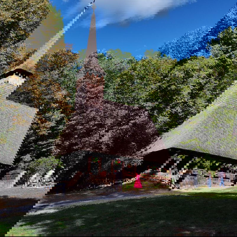 Blick auf eine Kapelle, die auf einer Waldlichtung steht.