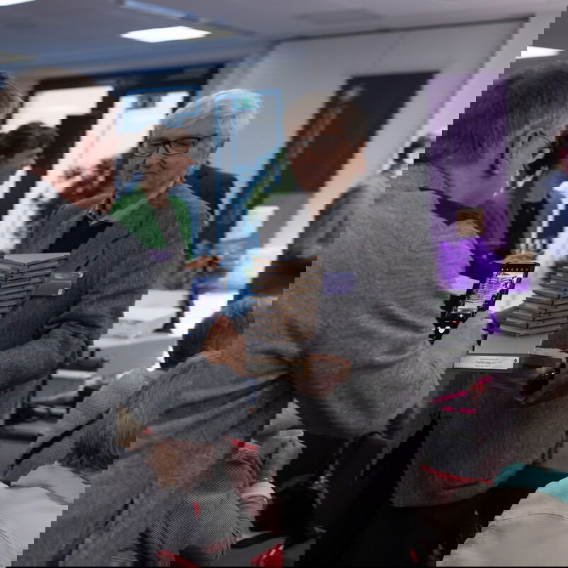 Ein männlich zu lesender Preisträger hält seinen Pokal für ein Foto in die Kamera.