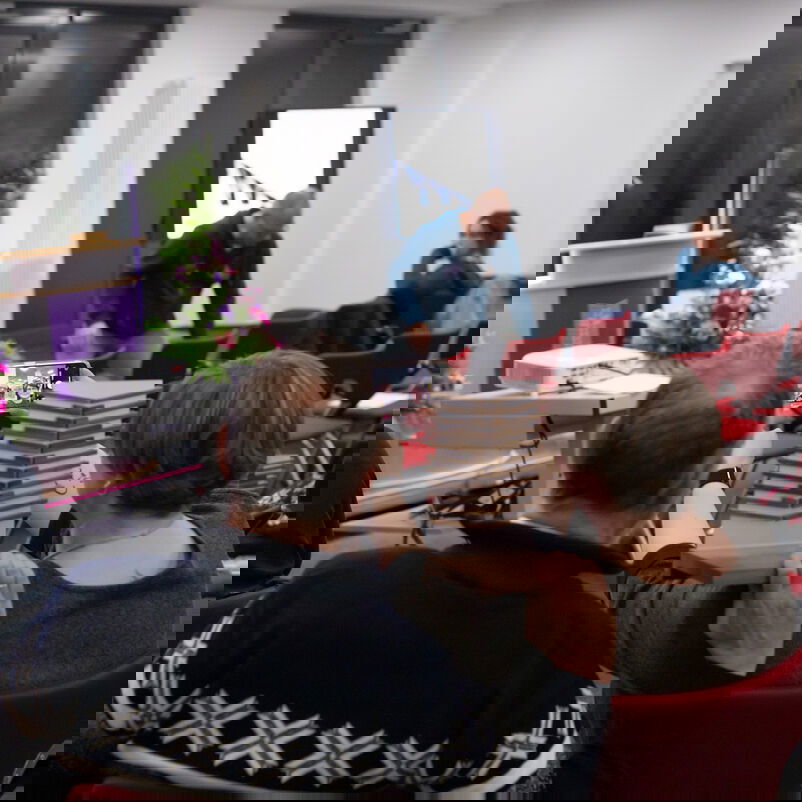 Zwei Personen machen ein Selfie und halten zwischen sich ihren Preis.