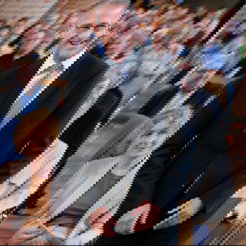 Eine männlich zu lesende Person steht im Kirchraum.