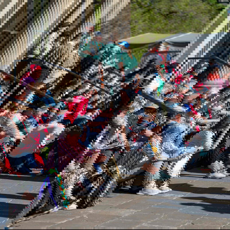 Menschen sitzen auf Treppenstufen.