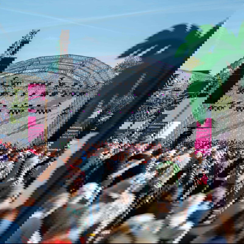 Blick über Menschen hinweg auf eine Bühne.