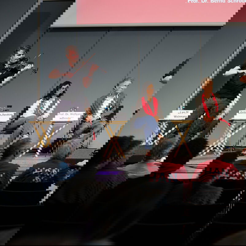 Eine Band, bestehend aus Schlagzeug, Geige und Cello.