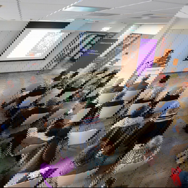 Menschen sitzen in Reihen.