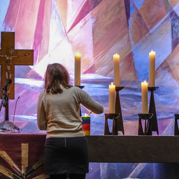 Eine Person zündet mehrere Kerzen an