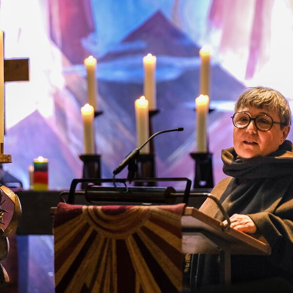 Eine weiblich lesbare Person vor Kerzen