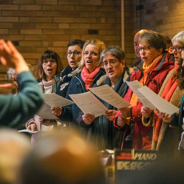Mehrere Personen mit Liedblättern