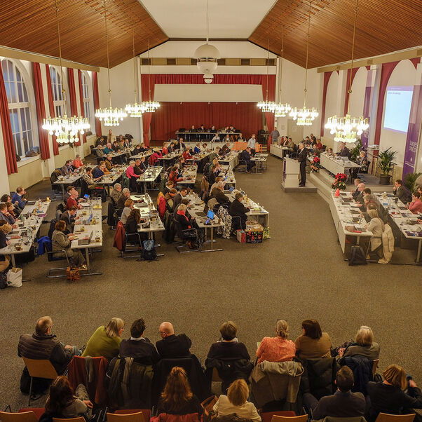 Mehrere Personen in einem Sitzungssaal
