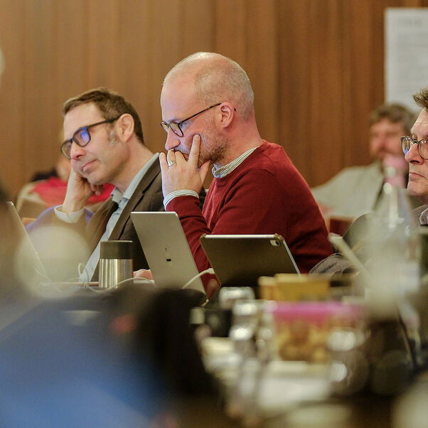 Mehrere Personen in einem Sitzungssaal