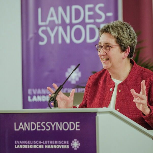 Eine weiblich gelesene Person mit kurzen grauen Haaren am Redepult. 