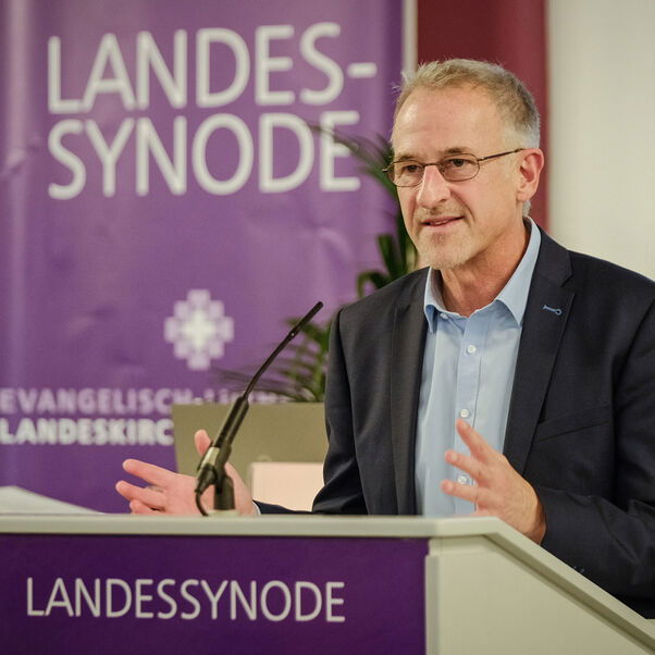 Eine männlich gelesene Person am Redepult. 