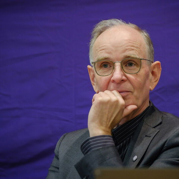 Eine männlich gelesene Person mit kurzen grauen Haaren und Brille. 