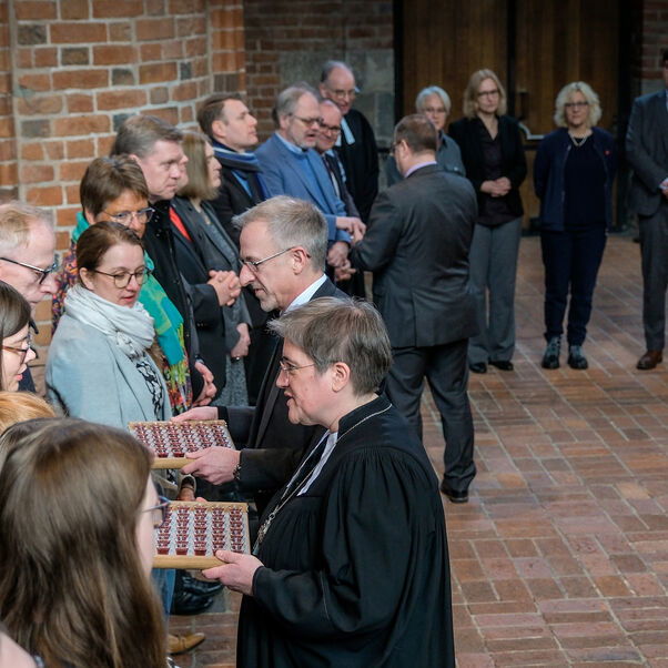 Viele Personen stehen im Halbkreis in einer Kirche