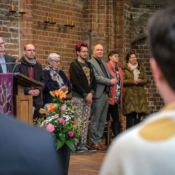 Mehrere Personen stehen in einer Reihe in einer Kirche