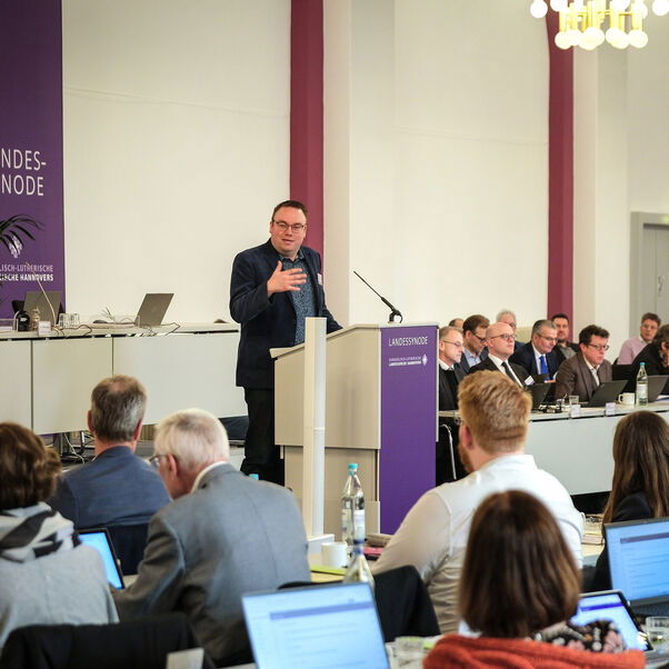 Mehrere Personen in einem Sitzungssaal