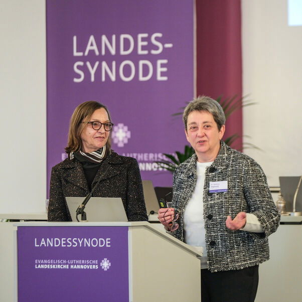 Zwei weiblich lesbare Personen an einem Rednerpult