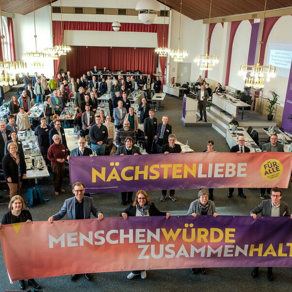 Viele Personen halten Banner mit der Aufschrift Nächstenliebe, Menschenwürde, Zusammmenhalt