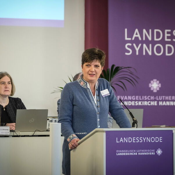 Eine weiblich lesbare Person an einem Rednerpult