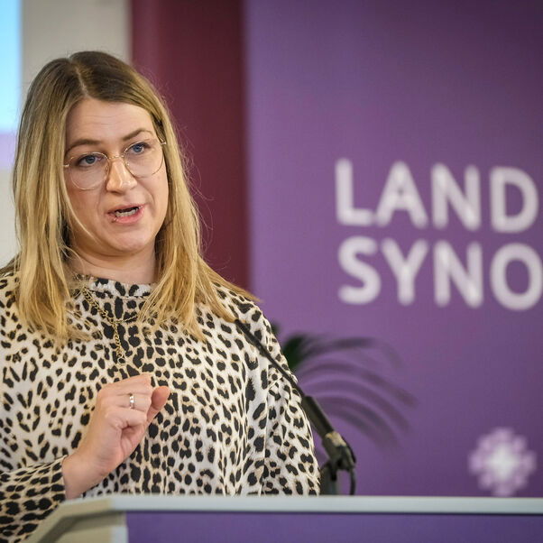 Eine weiblich lesbare Person an einem Rednerpult