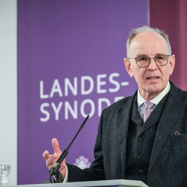 Eine männlich lesbare Person an einem Rednerpult