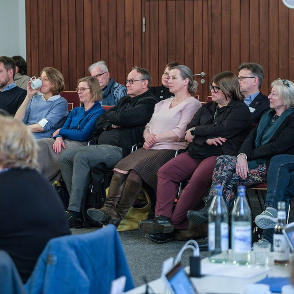 Mehrere Personen sitzen auf Stühlen