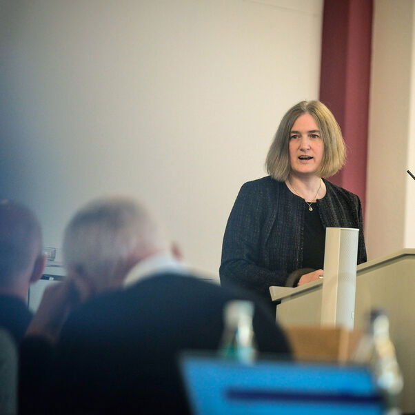 Eine weiblich lesbare Person an einem Rednerpult