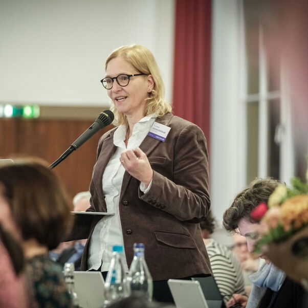 Eine weiblich lesbare Person an einem Mikrofon