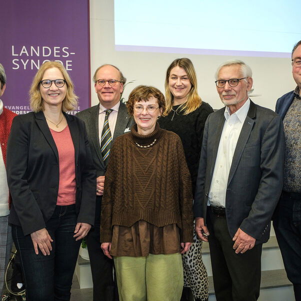 Mehrere Personen stehen zusammen und lächeln in die Kamera