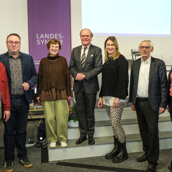 Mehrere Personen stehen zusammen und lächeln in die Kamera