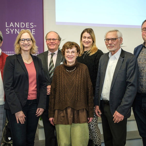 Mehrere Personen stehen zusammen und lächeln in die Kamera