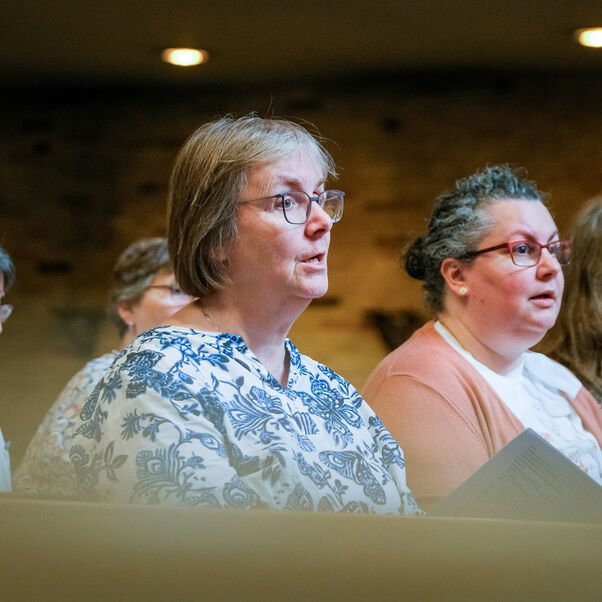 Mehrere Personen sitzen in einer Kirchenbank