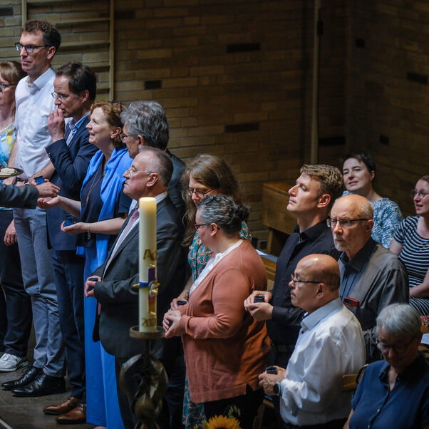 Viele Personen stehen im Inneren einer Kirche