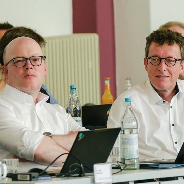 Zwei männlich lesbare Personen an einem Tisch