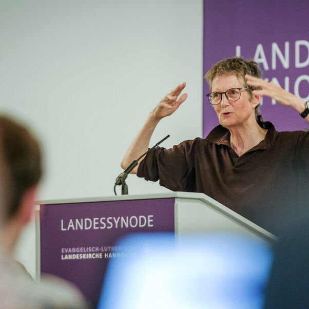 Eine weiblich lesbare Person an einem Rednerpult
