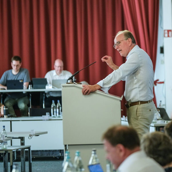Eine männlich lesbare Personen an einem Rednerpult