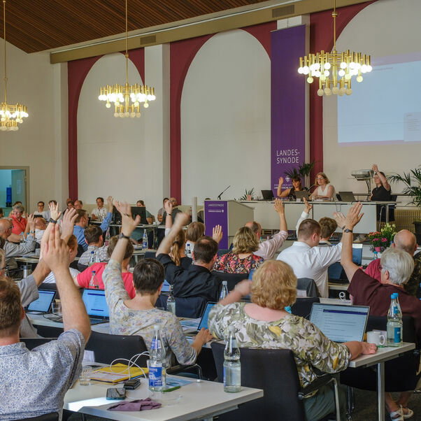 Viele Personen heben die Hand zur Abstimmung