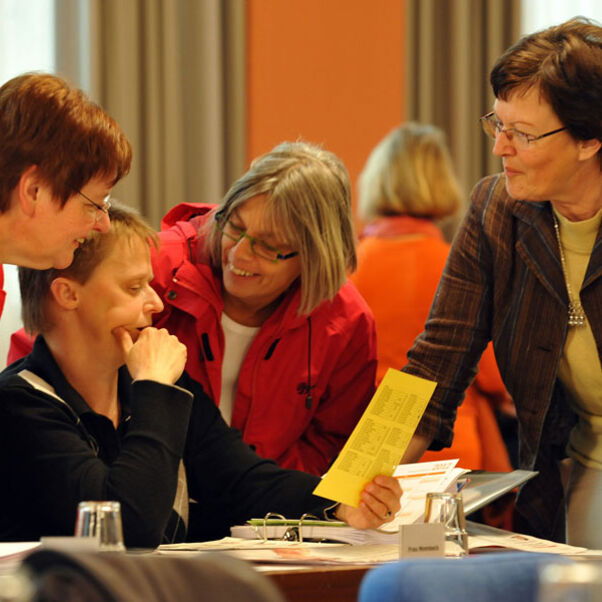 4 Frauen betrachten ein Faltblatt