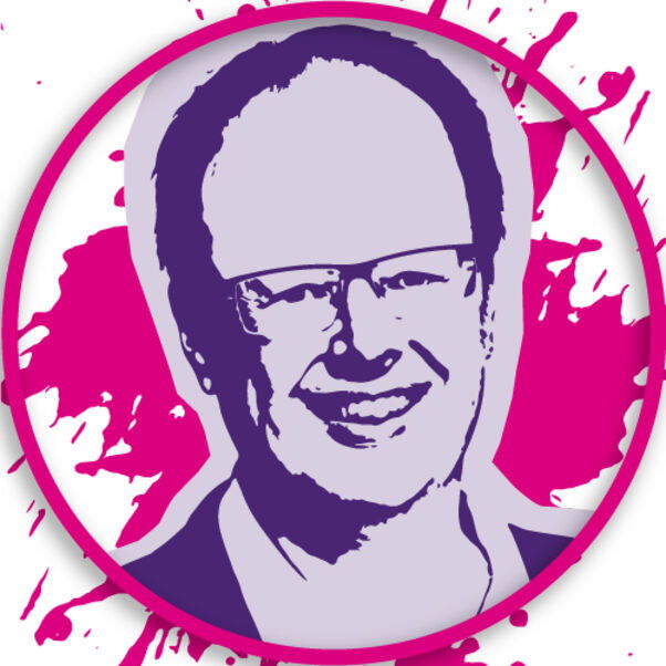 Eine männlich gelesene Person mit Brille, die lächelt.