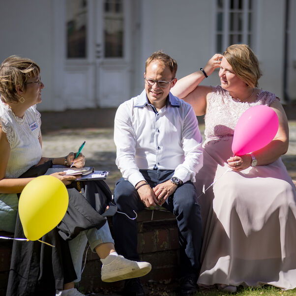 Ein Hochzeitspaar mit bunten Luftballons.