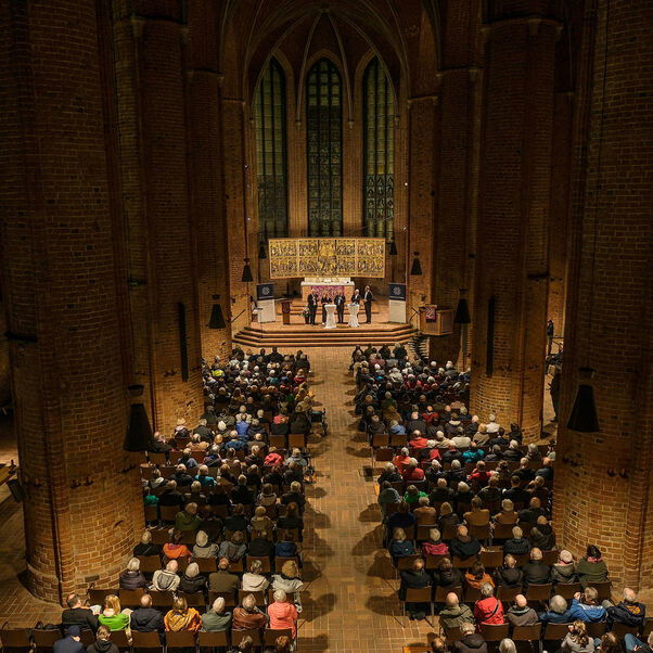 Eine Diskussion in einer Kirche mit vielen Besucherinnen und Besuchern