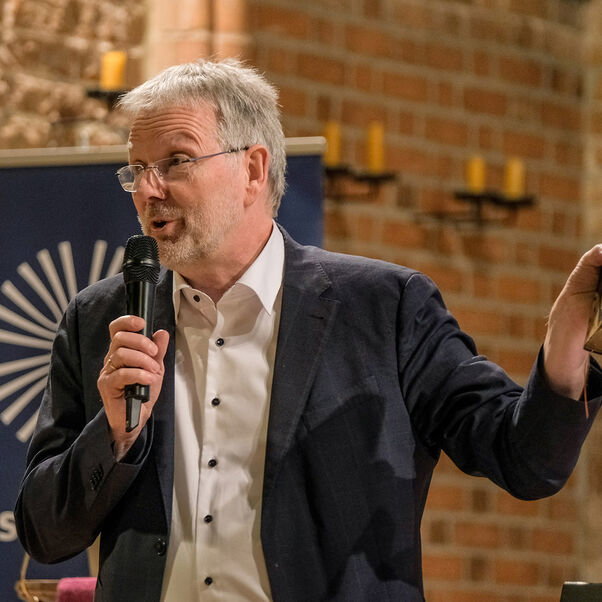 Eine Diskussion in einer Kirche mit vielen Besucherinnen und Besuchern