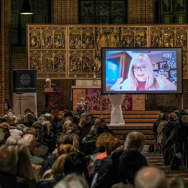 Eine Diskussion in einer Kirche mit vielen Besucherinnen und Besuchern