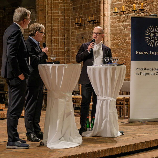 Eine Diskussion in einer Kirche mit vielen Besucherinnen und Besuchern