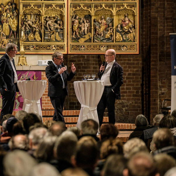 Eine Diskussion in einer Kirche mit vielen Besucherinnen und Besuchern